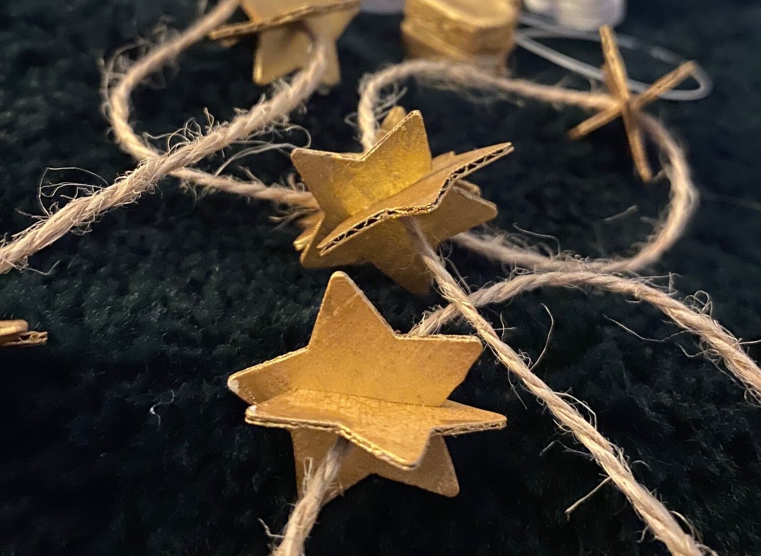 Using brown string gives your cardboard star garland a more rustic aesthetic, but jewellery wire can be used if you prefer a cleaner look.